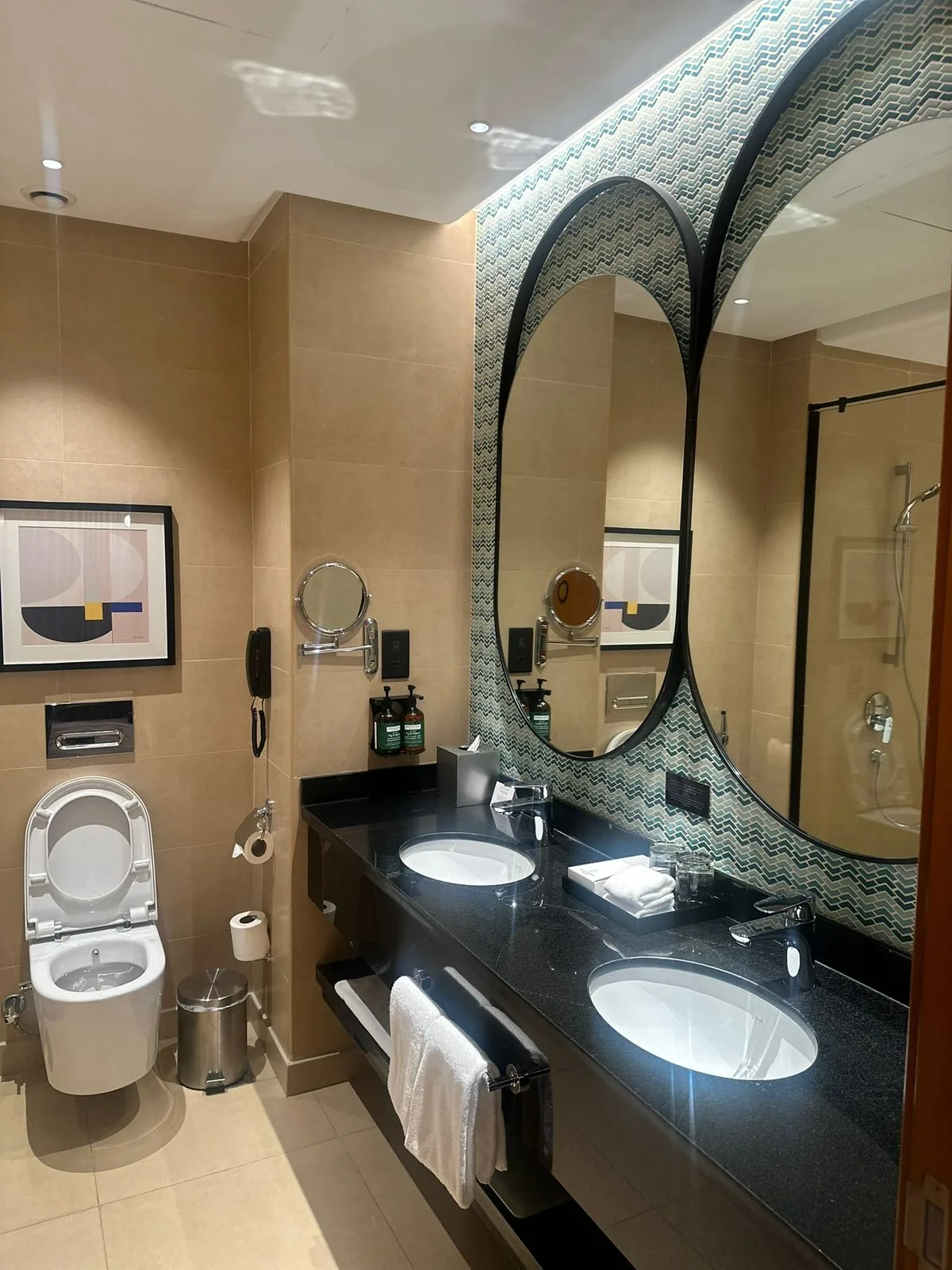 Guest bathroom with double vanity, patterned mosaic and round mirrors