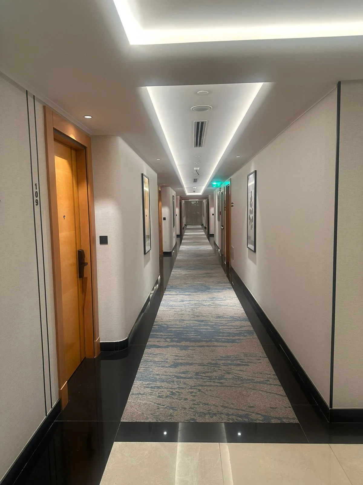 Guest-floor corridor with custom carpets and cove lighting