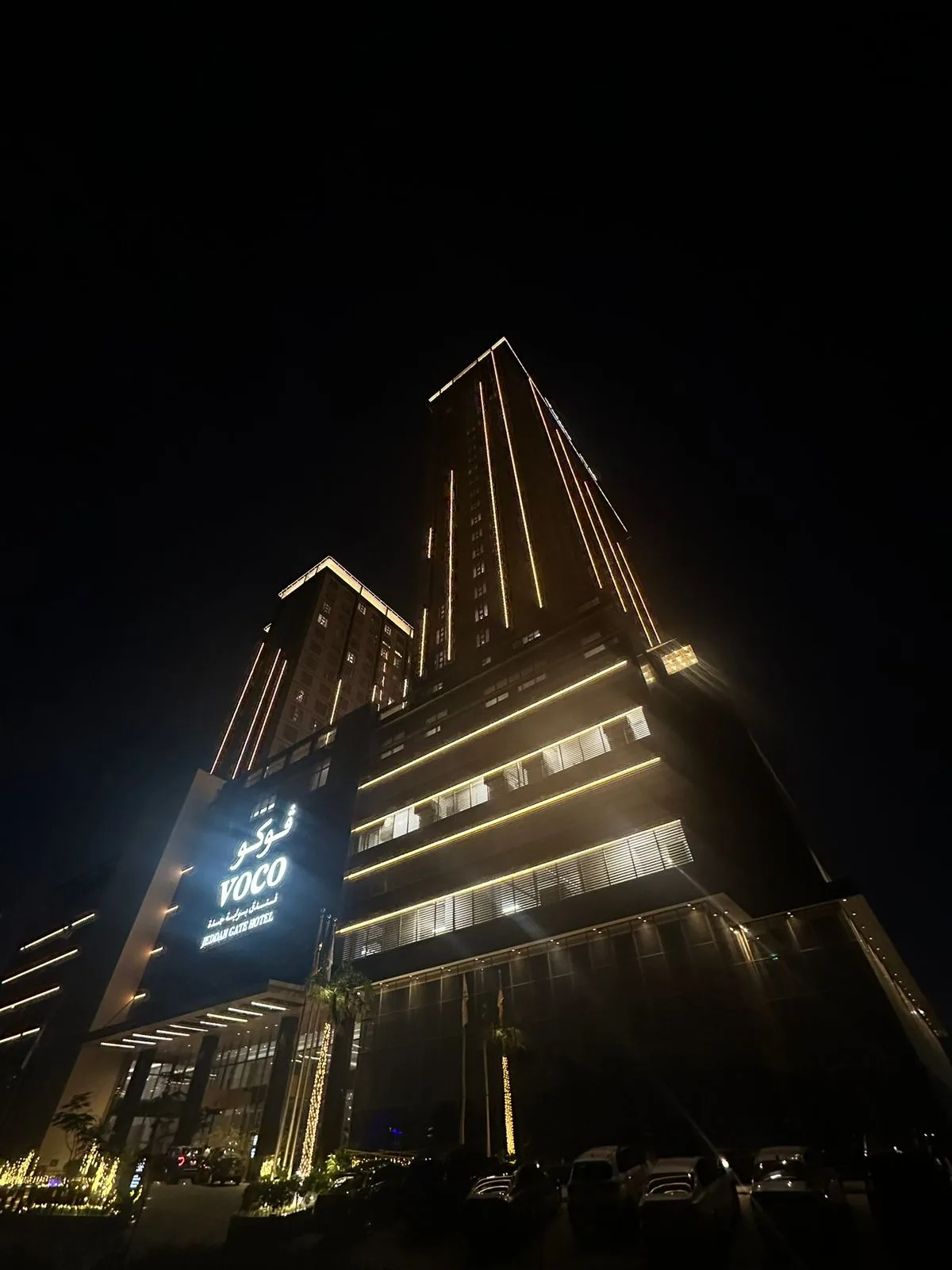 The voco Jeddah Gate tower illuminated at night in the Al-Faihaa district