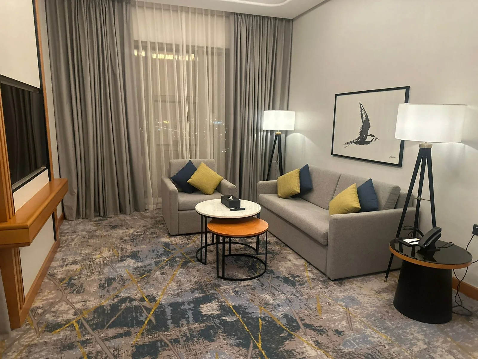 Suite living room furnished with contemporary sofas and layered lighting